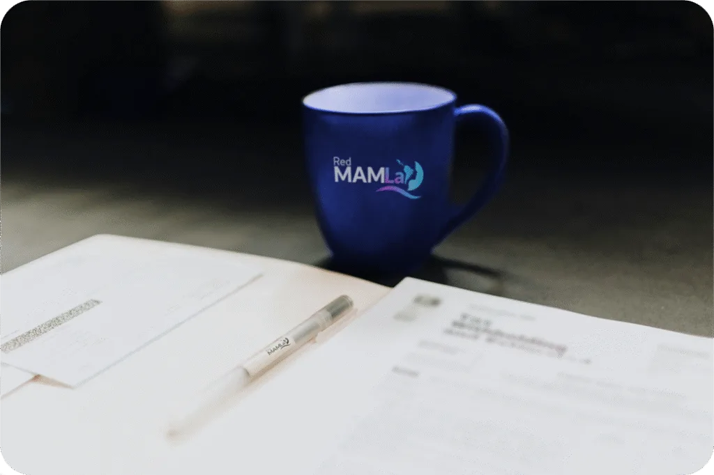 Taza de Red MAMLa sobre un cuaderno y una lapicera
