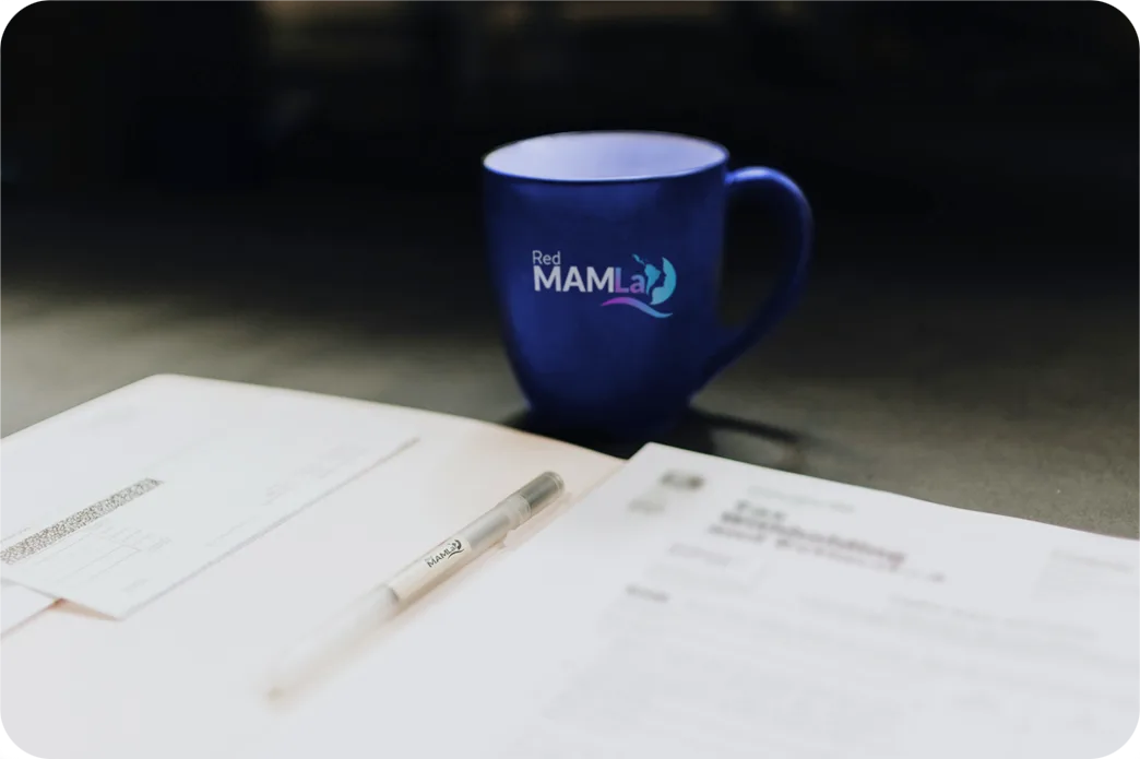 Taza de Red MAMLa sobre un cuaderno y una lapicera