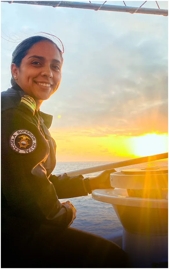 Mujer de la marina contemplando el atardecer desde la cubierta de un buque