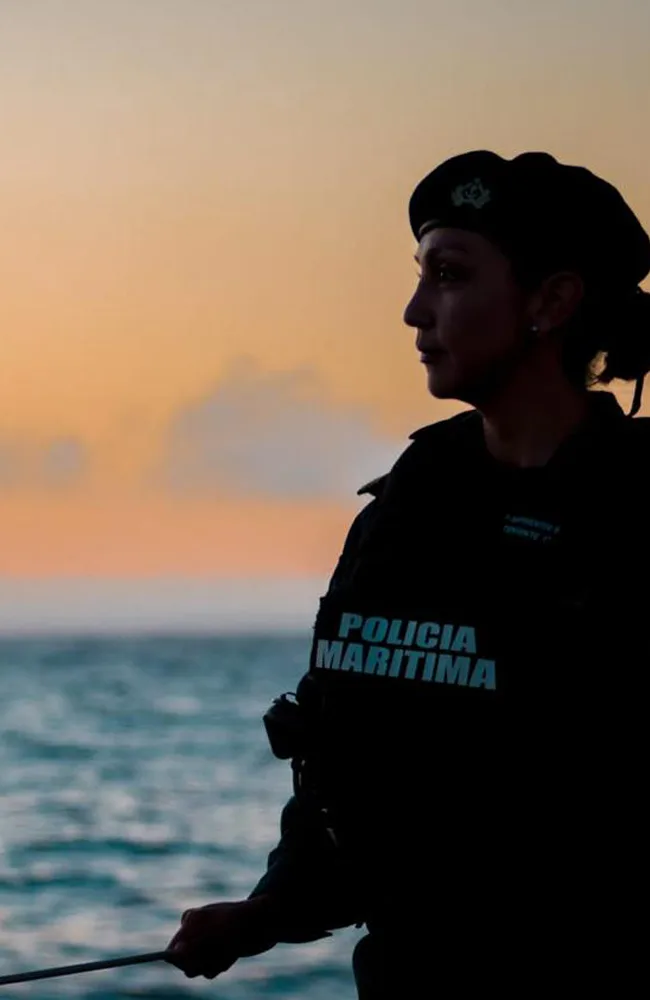 Silueta de una integrante de la policía marítima al atardecer
